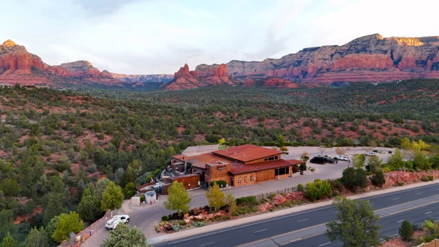 A restaurant sits below Sedona’s red rock cliffs with desert views in every direction