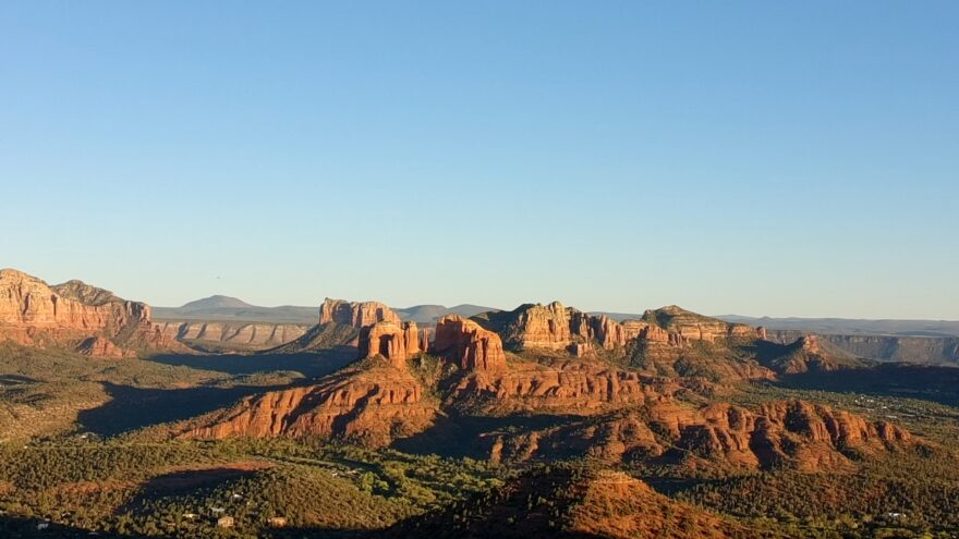 Golden light falls across Sedona’s red rock cliffs and desert valley
