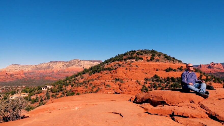 Man sitting quietly on red rocks at a Sedona vortex site