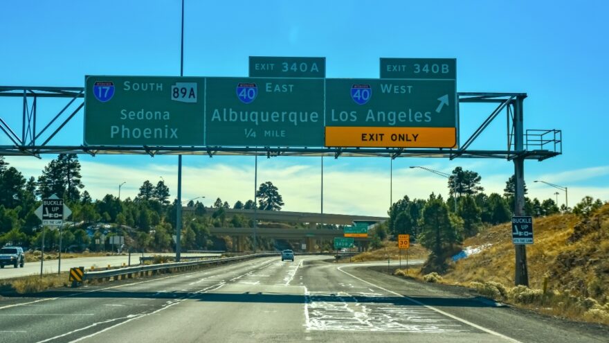 Highway signs point toward Sedona, Phoenix, Albuquerque, and Los Angeles