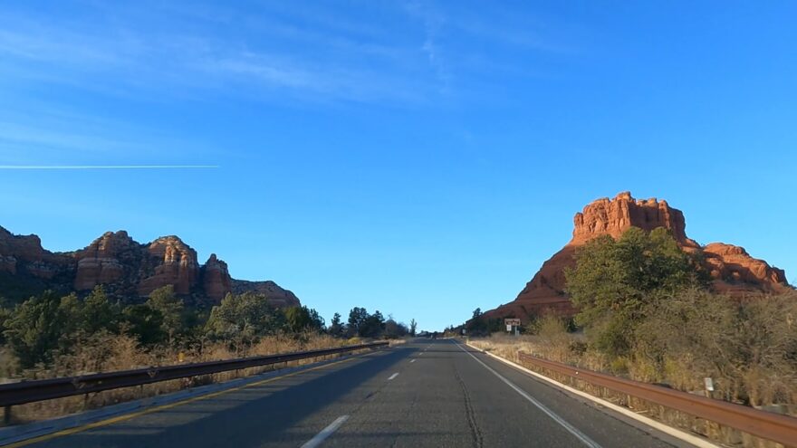 Cars drive along Red Rock Scenic Byway with Sedona’s red rocks ahead